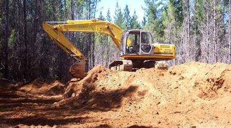 Excavadora construyendo camino forestal